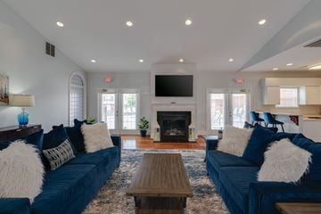 Lynchburg apartment for rent - a large living room with blue couches and a fireplace