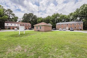 Portsmouth apartment for rent - a small brick building sitting in the middle of a grass field