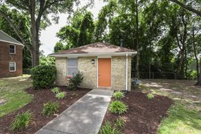 Portsmouth apartment for rent - a small brick building with an orange door and a sidewalk