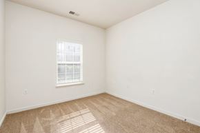 Richmond apartment for rent - a bedroom with white walls and carpet and a window