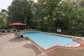 Mechanicsville apartment for rent - a swimming pool with chairs and a table and a umbrella