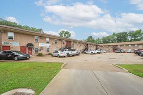 Norfolk apartment for rent - a parking lot in front of a brick building with cars parked