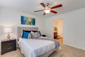 Richmond apartment for rent - A bedroom with a bed, a ceiling fan, and a painting on the wall.
