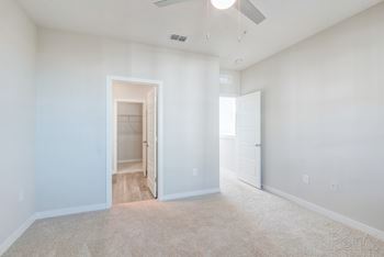 Bedroom with carpet, ceiling fan, and ensuite bathroom.