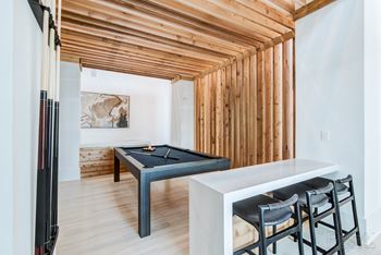 Gameroom with billiards table and barstools.