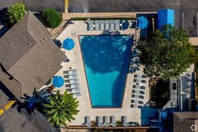 Mobile apartment for rent - An aerial view of a swimming pool surrounded by lounge chairs and umbrellas.