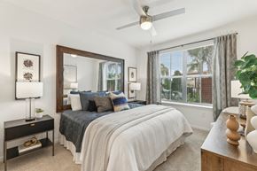Kissimmee apartment for rent - Primary bedroom with large window and ceiling fan at Tapestry Headwaters Apartments in Kissimmee, FL