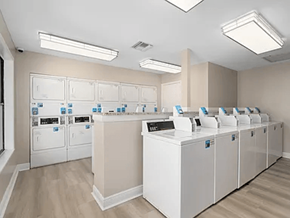 Mobile apartment for rent - A laundromat with rows of washers and dryers.