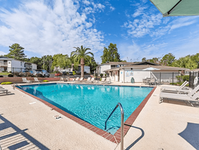 Mobile apartment for rent - A large swimming pool with a metal ladder and a red brick border.