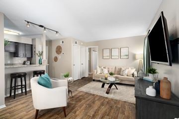 Mobile apartment for rent - A living room with a white chair and a brown coffee table.