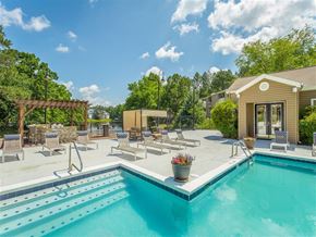 Birmingham apartment for rent - a swimming pool with lounge chairs next to a house