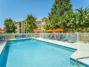 Birmingham apartment for rent - a swimming pool with blue chairs and orange umbrellas