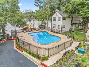 Daphne apartment for rent - a swimming pool is surrounded by a fence and a house