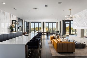 Huntsville apartment for rent - A modern living room with a long white sofa and a black counter.