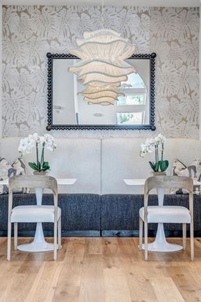 St. Augustine apartment for rent - A dining room with a white table and chairs, a mirror, and a wallpapered wall.