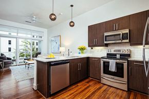 Birmingham apartment for rent - Kitchen island with granite countertop and pendant lighting at Reserve on 3rd Apartments, Birmingham, AL 35233