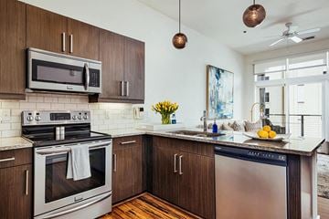Birmingham apartment for rent - A modern kitchen with dark wood cabinets and stainless steel appliances.