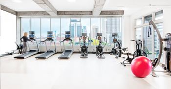 Fitness center with cardio equipment and city views
