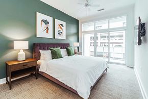 Birmingham apartment for rent - Bedroom with green accent wall and large windows at Reserve on 3rd Apartments, Birmingham, AL