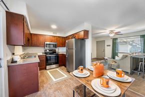 Baton Rouge apartment for rent - a kitchen and dining area with wooden cabinets and stainless steel appliances  at Retreat at Brightside Apartments in Baton Rouge, LA