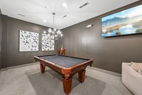 Columbus apartment for rent - A pool table in a room with a painting on the wall and a couch.