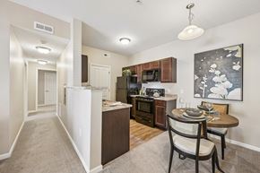 Columbus apartment for rent - A kitchen with a table and chairs in the foreground and a painting hanging on the wall.