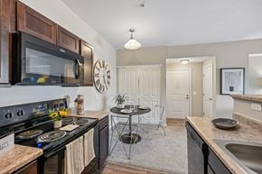 Columbus apartment for rent - A kitchen with a black stove top oven and a black microwave above it.