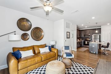 Pensacola apartment for rent - A living room with a brown leather couch and a black and white checkered rug.