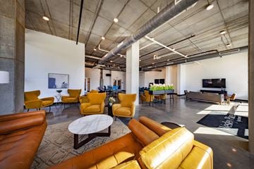 Indianapolis apartment for rent - A modern living room with yellow chairs and a white coffee table.