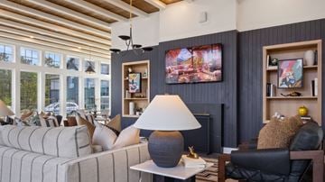 Homewood apartment for rent - A living room with a grey couch, a black chair, a lamp, and a painting on the wall.