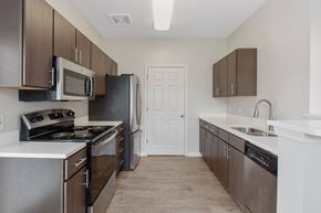 Daphne apartment for rent - A kitchen with brown cabinets and stainless steel appliances.