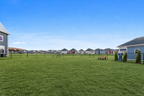 Huntsville apartment for rent - A grassy field with a row of houses in the background.