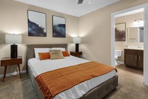 Pensacola apartment for rent - A bedroom with a connected bathroom and a ceiling fan at Crystal Lake in Pensacola, Florida.