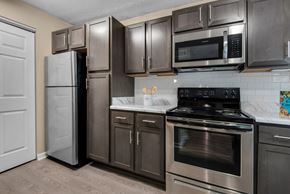 Pensacola apartment for rent - A kitchen with a black stove top oven and stainless-steel appliances at Crystal Lake in Pensacola, Florida.