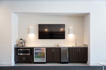 A kitchen with a counter and a microwave and a television