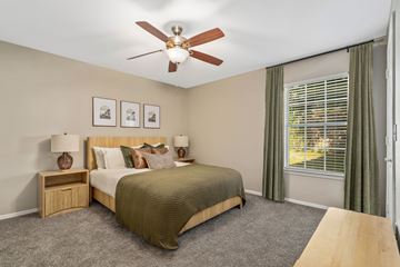 Biloxi apartment for rent - A bedroom with a bed, nightstands, and a ceiling fan.