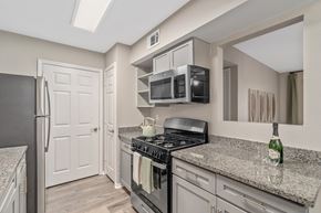 Biloxi apartment for rent - A kitchen with a black stove top oven and a black refrigerator.