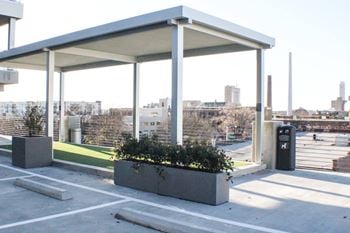 A covered parking lot with a city in the background