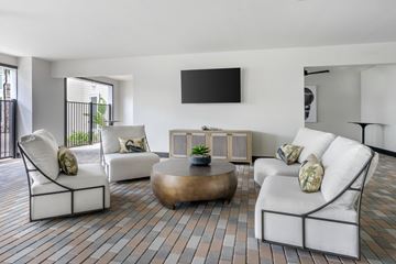 Lutz apartment for rent - A living room with white furniture and a flat screen TV mounted on the wall.