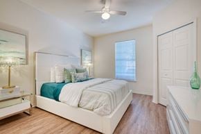 Port Orange apartment for rent - A bedroom with a bed, nightstand, and a ceiling fan.