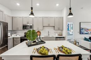 Sarasota apartment for rent - A modern kitchen with island and stainless steel appliances at Tapestry University Park apartments in Sarasota, FL