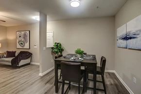 Fayetteville apartment for rent - A dining room with a table set for two and a couch with a throw blanket.