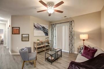 Fayetteville apartment for rent - A living room with a grey chair and a white couch.