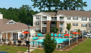 Fayetteville apartment for rent - A large apartment complex with a pool and a fence.