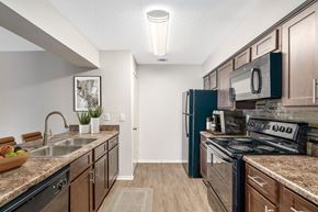 Mobile apartment for rent - Staged kitchen area with dark wood cabinets and black appliances at Oakley at hillcrest in west mobile, al