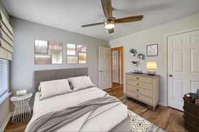 Tuscumbia apartment for rent - A bedroom with a bed, a ceiling fan, and a nightstand with a lamp.