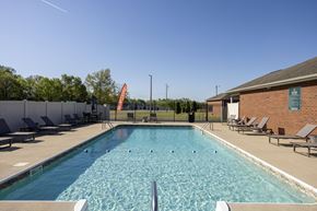 Florence apartment for rent - A large outdoor swimming pool surrounded by lounge chairs and a fence.