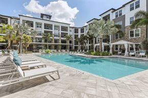 Apollo Beach apartment for rent - a swimming pool with lounge chairs and a building in the background