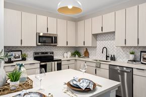 Mobile apartment for rent - A modern kitchen with a white countertop and a microwave above it.