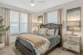 Mobile apartment for rent - A bedroom with a large bed, a ceiling fan, and a painting on the wall.